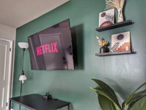 uma sala de estar com televisão numa parede verde em Stylish & Cozy #1 8 mins to DCA & Washington DC em Alexandria