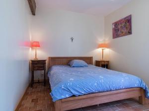 a bedroom with a bed with a blue comforter and two lamps at Cottage in an old remote farmhouse in Giroux +29 photos
