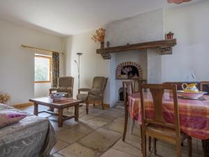 a living room with a table and a fireplace at Cottage in an old remote farmhouse in Giroux