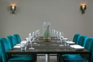 a long table with wine glasses and blue chairs at Wyndham Stuttgart Airport Messe in Stuttgart
