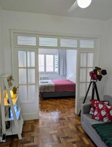 a bedroom with a bed and a couch in a room at Espaçoso flat in Copacabana in Rio de Janeiro