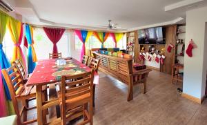 a dining room with a table and chairs and curtains at Popoyo Beach Home in Tola