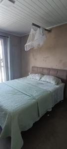 a bedroom with a large bed with a blue comforter at Casa de campo in Santana do Livramento