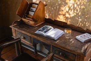 una scrivania in legno con un libro e un bicchiere di drink di Enkusero Mara ad Aitong Altre 37 foto