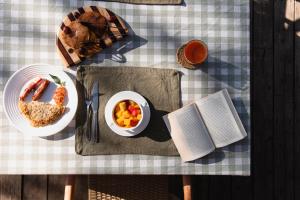 un tavolo con un piatto di cibo e un libro di Enkusero Mara ad Aitong