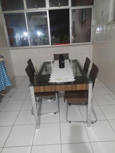 einen Glastisch mit Stühlen in einem Zimmer mit Fenstern in der Unterkunft Centro - Perto de tudo in Salvador