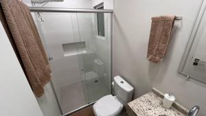 a bathroom with a toilet and a glass shower at Apartamento Perto do Centro Vaga de Garagem in Foz do Iguaçu +16 photos
