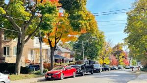 a truck and a red car parked on a street at A bright and tidy room in midtown near subway in Toronto +12 photos