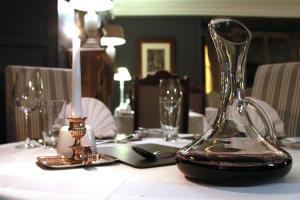 a table with a candle and a glass vase on it at The Brownlow Arms Inn in Grantham