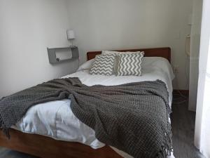 ein Bett mit einer Decke und Kissen darauf in der Unterkunft Mucho cielo y mucho mar in Punta Colorada