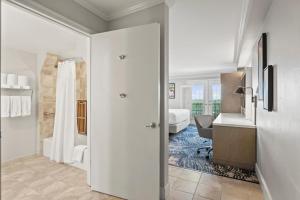 a white room with a bedroom and a desk at Crowne Plaza Orlando-Downtown by IHG in Orlando