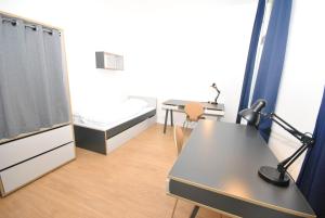 プラハにあるBelgicka Executive Apartmentsのデスク、ベッド、テーブルが備わる客室です。