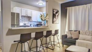 a kitchen with a bar with chairs and a couch at Stylish & Cozy #3 8 mins to DCA & Washington DC in Alexandria