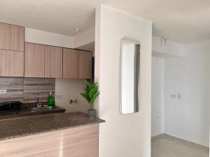 a kitchen with white walls and wooden cabinets at Max House 503 in Soledad