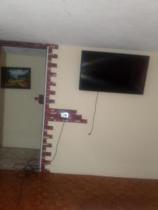 a flat screen tv hanging on a wall at Crocro house in Baños