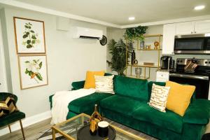 a living room with a green couch with pillows at Modern 1BR Unit with Free Parking Walk to Metro in Washington