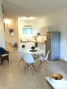 una cucina e una sala da pranzo con tavolo e sedie di Pissouri Beach House - Image a Pissouri