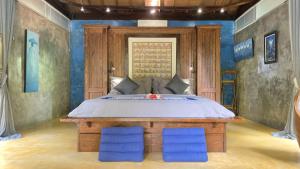a bedroom with a bed with two blue chairs at Maso Christian Villa in Tumbak Bayuh +34 photos