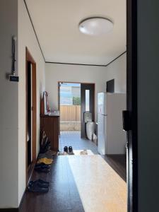 un corridoio con scarpe sul pavimento di una cucina di 民宿 中部国际机场 常滑站 a Tokoname