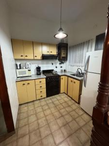 a kitchen with yellow cabinets and a white refrigerator at CasaSansaba in Gerli +7 photos