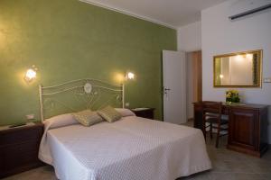 a bedroom with a white bed and a green wall at B&B Corte dell' Immacolata in Taviano
