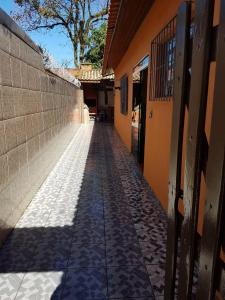 une allée vide avec un bâtiment et un arbre dans l'établissement Casa de praia, à Itanhaém