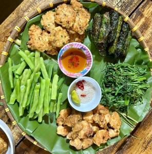 a plate of food with vegetables on a banana leaf at Hoa Phong homestay Moc Chau in Mộc Châu