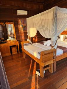 a bedroom with a bed with a mosquito net at Beji Ayu Villas Sidemen in Sidemen