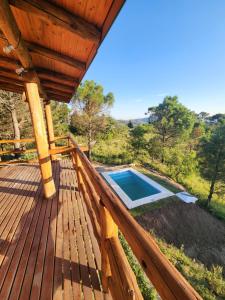 a wooden deck with a swimming pool on it at Cabaña La Lechuza in Villa Ciudad de America