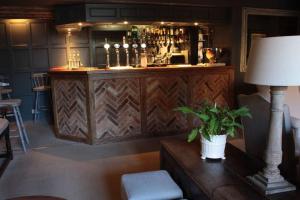 un bar con una mesa con una lámpara y una planta en The Brownlow Arms Inn, en Grantham