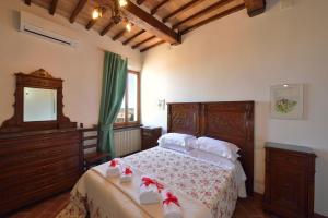 1 dormitorio con 1 cama con tocador y espejo en La Corte Medicea en Montepulciano
