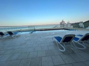 a row of lounge chairs sitting next to a swimming pool at Nuevo SMART-HOME de Lujo a Playa Rodadero con Piscina Panorámica in Gaira