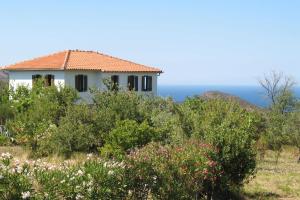 een huis op een heuvel met de oceaan op de achtergrond bij Traditional Stonehouse in Potistika +38 foto's