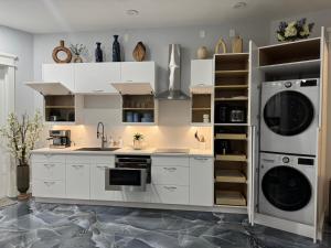 a kitchen with white cabinets and a washer and dryer at Serene Stays Naples in Naples