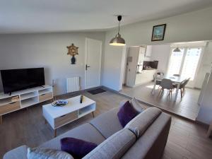 a living room with a couch and a table at Maison plain-pied Châtelaillon-Plage à 500m de l'océan pour 6 pers, jardin, barbecue - FR-1-706-37 in Châtelaillon-Plage