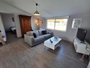 a living room with a couch and a table at Maison plain-pied Châtelaillon-Plage à 500m de l'océan pour 6 pers, jardin, barbecue - FR-1-706-37 in Châtelaillon-Plage +12 photos