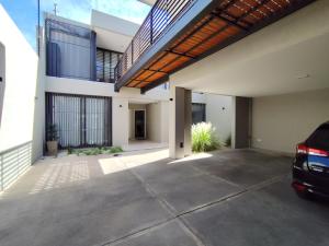 a house with a car parked in a driveway at San Vicente in Godoy Cruz