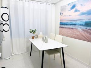 Un comedor blanco con una mesa y sillas blancas. en Cozy 2BR Netflix Metro 5min Jamsil,Gangnam, en Seongnam 10 fotos más