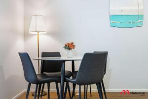 シドニーにあるMetaWiseBnB Studio Dixon Next to ICC & Darling Harbour 43の椅子4脚とランプが付いたテーブル