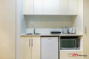 シドニーにあるMetaWiseBnB Studio Dixon Next to ICC & Darling Harbour 43のシンクと電子レンジのある小さなキッチン
