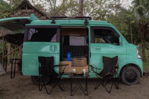 a green van parked with two chairs and a table at Camper Van for Rent-Mini , El Nido in El Nido