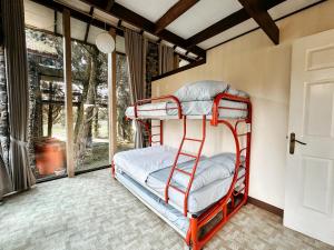 a bunk bed in a room with a window at De Villa Istana Bunga Lembang by YourHome in Tegalharendong