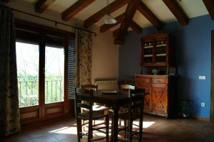 comedor con mesa, sillas y ventana en Apartamentos Casa Vidal, en Adahuesca