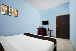 Un dormitorio con una cama y un escritorio con televisión. en Hotel O Spacious Villa, en Bhubaneshwar