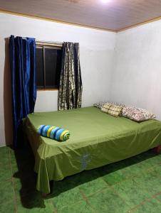 a small bed in a room with a window at Cabaña el mirador in San José +2 photos