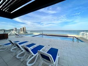 a group of chairs sitting next to a swimming pool at Nuevo SMART-HOME de Lujo a Playa Rodadero con Piscina Panorámica in Gaira