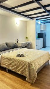 a bedroom with a large bed and a kitchen at Relajante y Cómodo Apartaestudio en La Rambla in Manizales