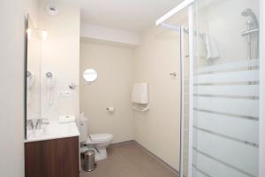 a bathroom with a toilet and a shower at Appart'hôtel Odalys City - Orléans Centre in Orléans