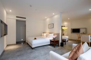 a hotel room with a bed and a couch at Mount Emei Heyuan Serene Residence Hot Spring Hotel in Emeishan City