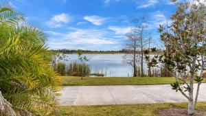 Una pasarela que conduce a un lago con árboles al fondo. en Master Room with Private Bath nearby Conv Center & Epic, en Orlando